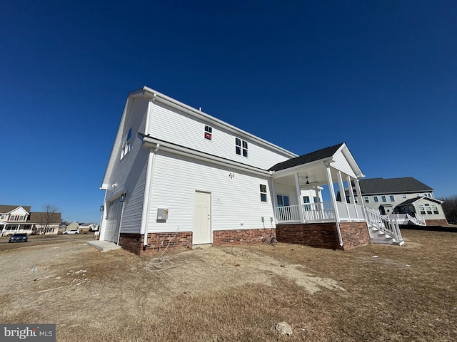 back of property featuring a porch, a garage, and ceiling fan