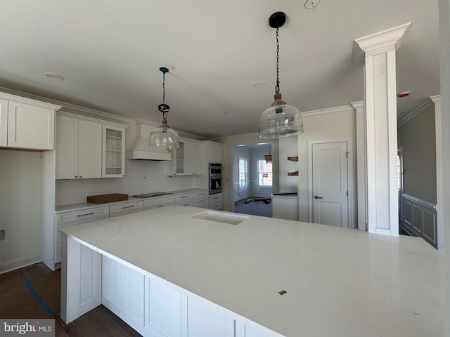 kitchen featuring white cabinetry, ornamental molding, black gas cooktop, and hanging light fixtures