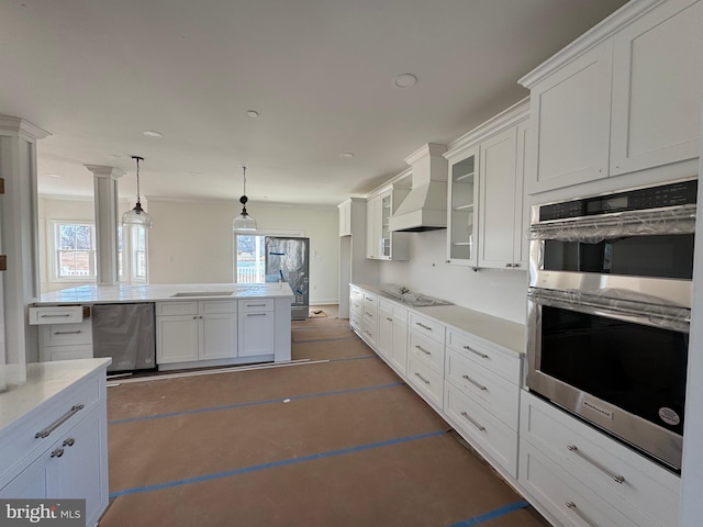 kitchen featuring stainless steel appliances, premium range hood, pendant lighting, and white cabinetry