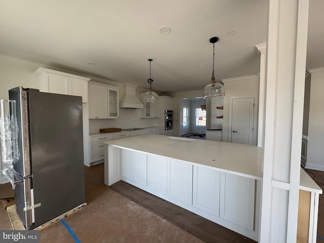 kitchen featuring premium range hood, white cabinets, hanging light fixtures, ornamental molding, and stainless steel appliances