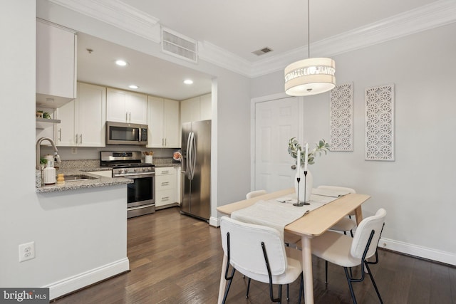 kitchen with sink, kitchen peninsula, light stone counters, white cabinetry, and stainless steel appliances