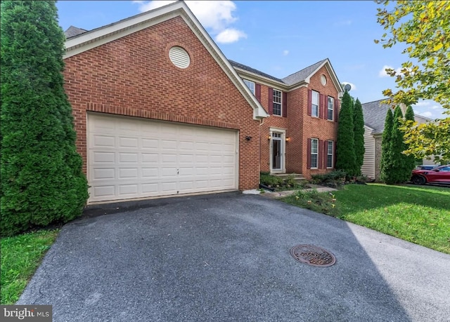 view of front of property with a front yard and a garage