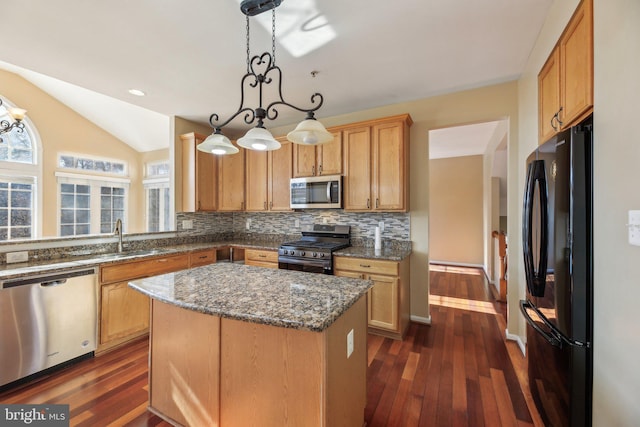 kitchen featuring stainless steel appliances, decorative light fixtures, tasteful backsplash, dark stone counters, and a kitchen island