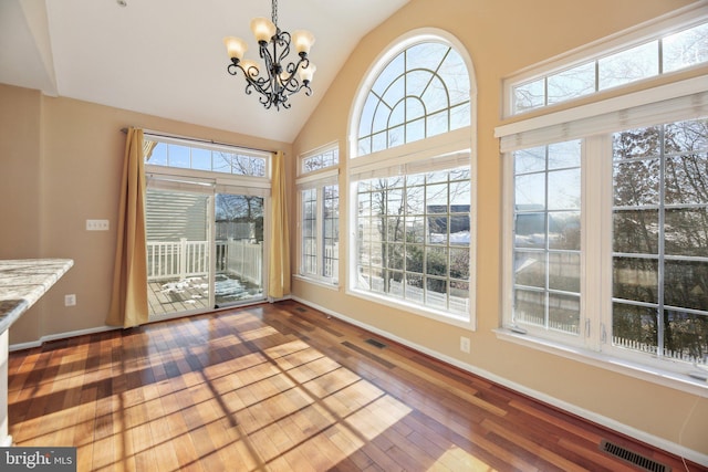 unfurnished sunroom featuring a notable chandelier and vaulted ceiling