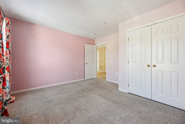 unfurnished bedroom featuring a closet and light carpet