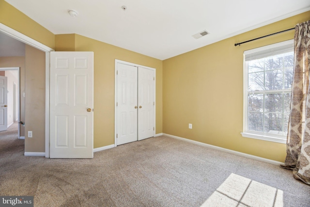 unfurnished bedroom featuring carpet floors and a closet