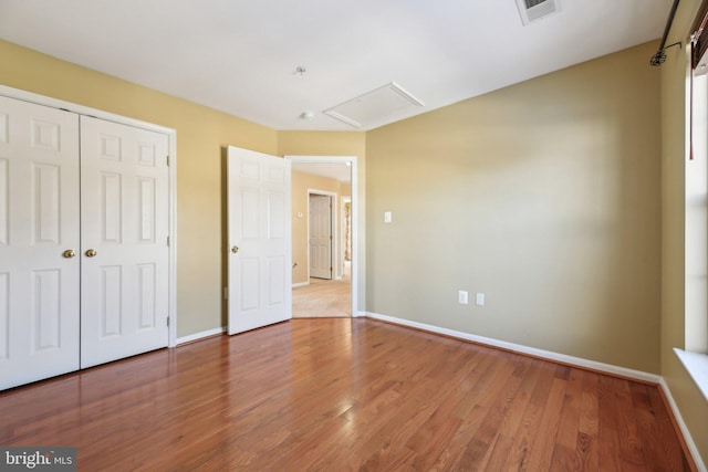 unfurnished bedroom with wood-type flooring and a closet