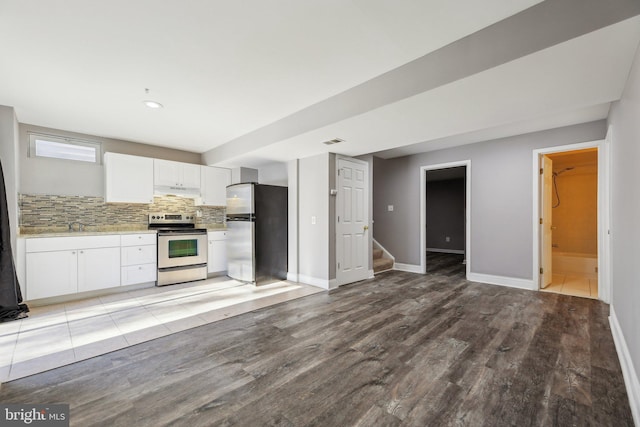 kitchen with sink, white cabinets, light hardwood / wood-style flooring, backsplash, and appliances with stainless steel finishes