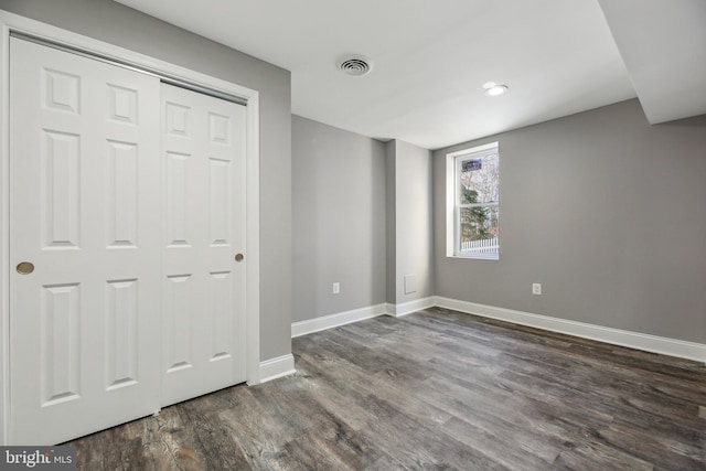 unfurnished bedroom featuring dark hardwood / wood-style flooring and a closet