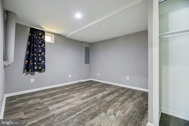 basement featuring electric panel and dark hardwood / wood-style floors