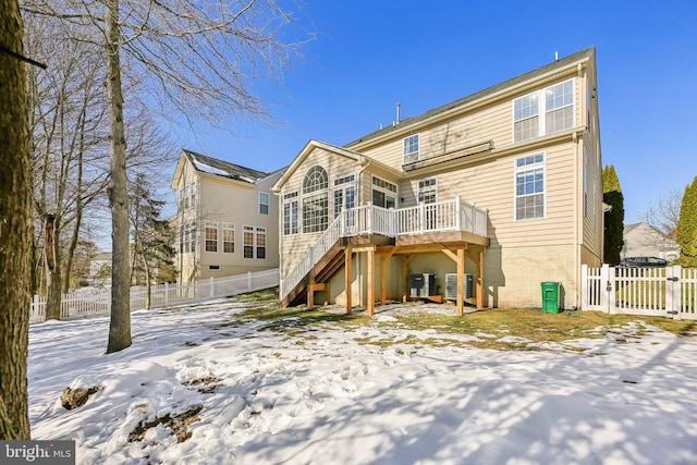 snow covered rear of property with a deck and central air condition unit