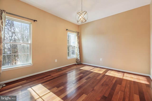 unfurnished room featuring dark wood-type flooring and a chandelier