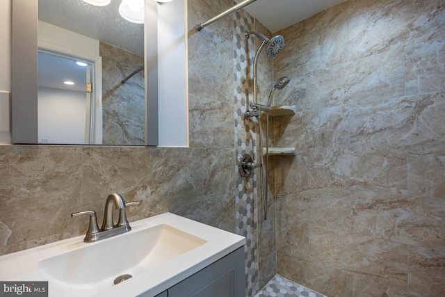 bathroom featuring decorative backsplash, tiled shower, and vanity