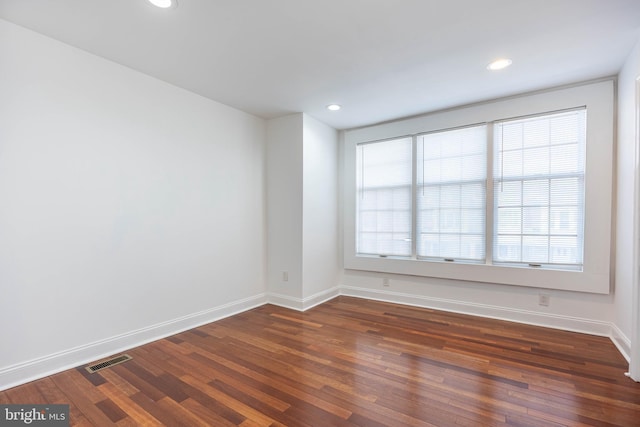 spare room with dark hardwood / wood-style flooring