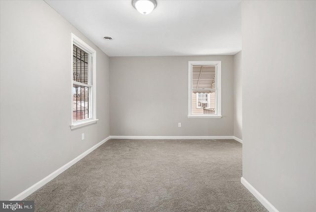 carpeted spare room featuring a wealth of natural light