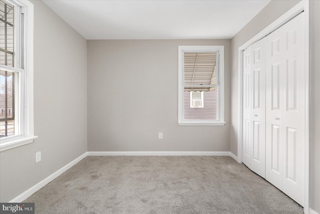 unfurnished bedroom featuring a closet and light carpet