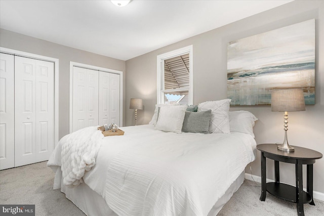 carpeted bedroom featuring two closets