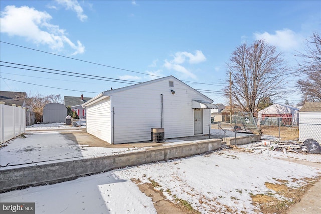 view of snow covered exterior with a shed