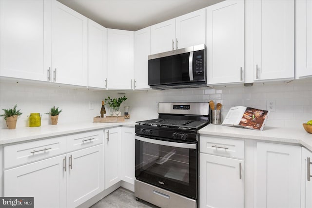 kitchen with decorative backsplash, white cabinetry, and stainless steel appliances