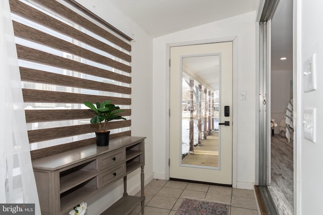 entryway with vaulted ceiling and light tile patterned floors