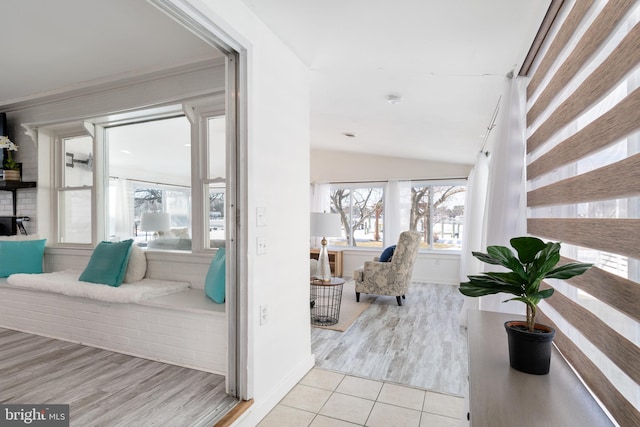 interior space featuring light tile patterned flooring, a wealth of natural light, and vaulted ceiling