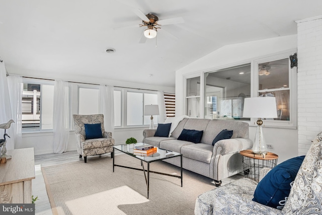 living room featuring lofted ceiling, light wood-type flooring, and ceiling fan