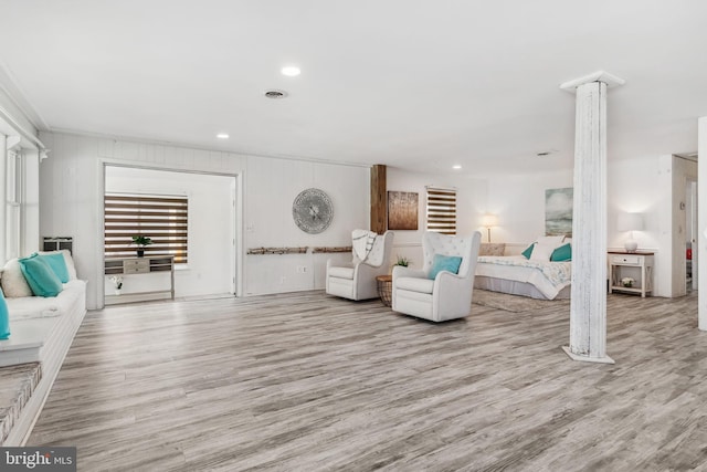 living room featuring light hardwood / wood-style floors and ornate columns