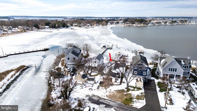 snowy aerial view featuring a water view