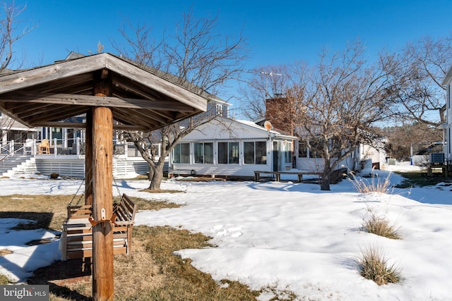 view of snow covered rear of property