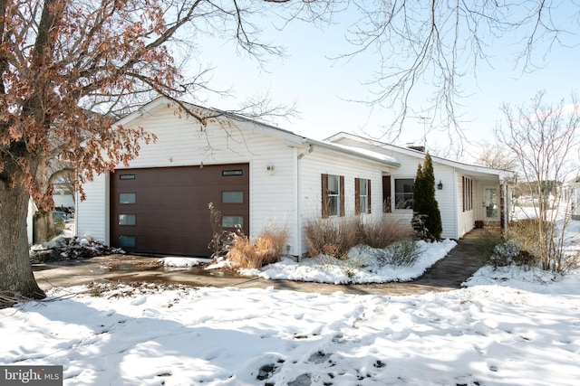 view of snow covered exterior with a garage