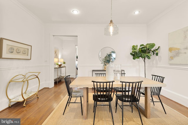 dining room featuring hardwood / wood-style floors and crown molding