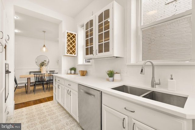 kitchen with decorative light fixtures, white cabinetry, sink, decorative backsplash, and stainless steel dishwasher