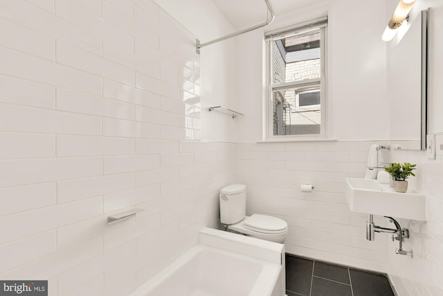 bathroom featuring shower / tub combination, toilet, tile patterned flooring, and tile walls