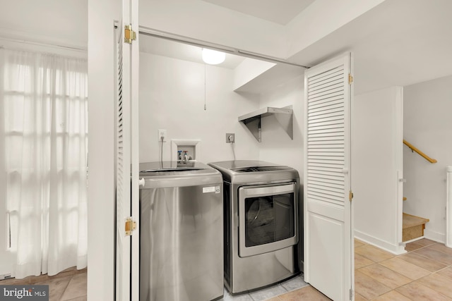 clothes washing area featuring washer and dryer and light tile patterned floors