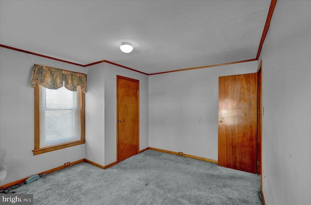 spare room featuring baseboards, ornamental molding, and light colored carpet