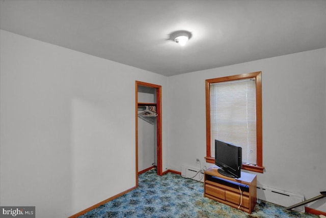 bedroom with light carpet, a baseboard heating unit, a closet, and baseboards