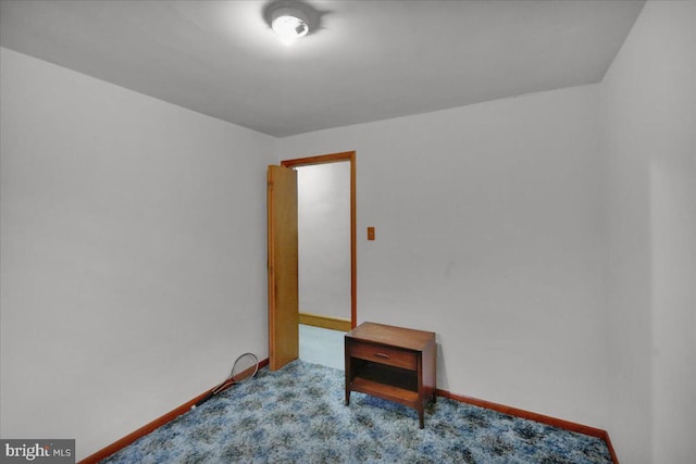 empty room featuring light colored carpet and baseboards