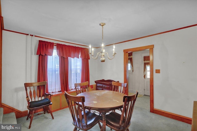 dining area featuring crown molding, carpet floors, baseboards, and an inviting chandelier