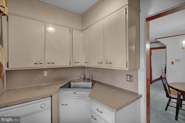 kitchen featuring dishwasher, light countertops, a sink, and white cabinetry