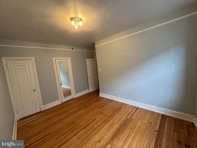 unfurnished bedroom featuring a textured ceiling and wood-type flooring