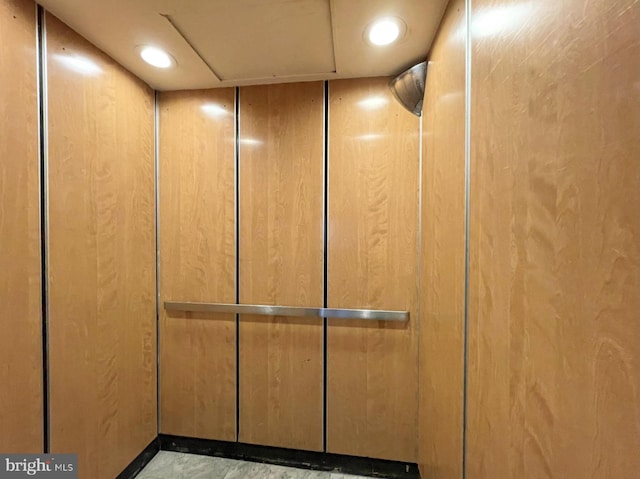 interior details featuring wood walls and elevator