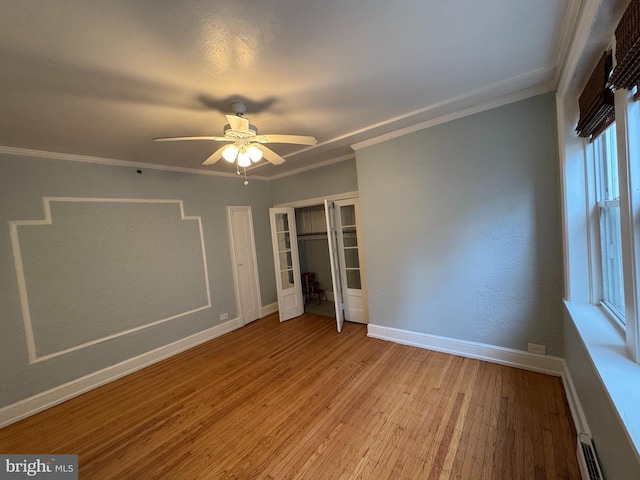 unfurnished bedroom featuring ceiling fan, a baseboard radiator, ornamental molding, and light hardwood / wood-style floors