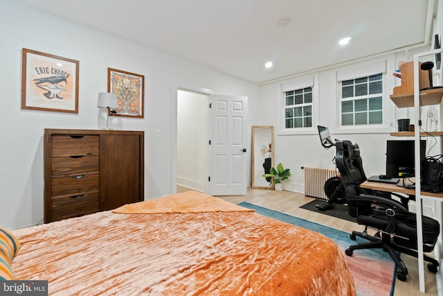 bedroom featuring radiator and light hardwood / wood-style flooring