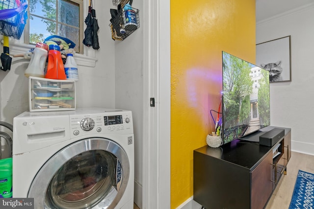 laundry room with light hardwood / wood-style floors, washer / dryer, and ornamental molding