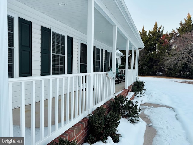 view of snow covered exterior with a porch