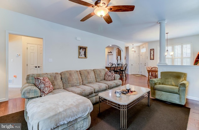 living room with decorative columns, hardwood / wood-style flooring, and ceiling fan