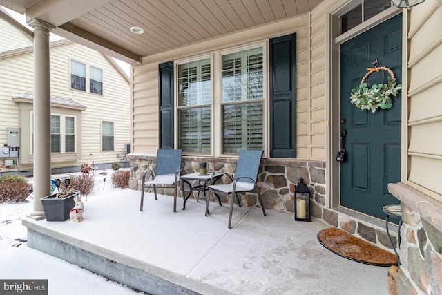 snow covered patio featuring a porch