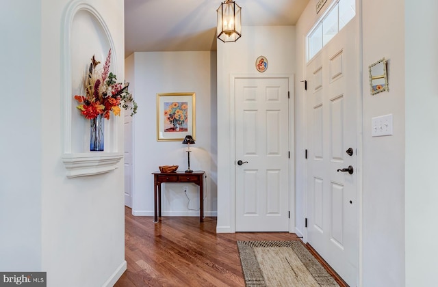 foyer entrance with a notable chandelier and hardwood / wood-style flooring