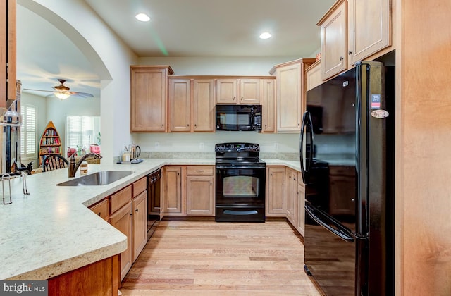 kitchen featuring black appliances, sink, kitchen peninsula, light wood-type flooring, and ceiling fan