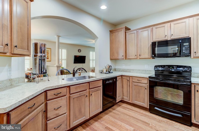 kitchen featuring ornate columns, kitchen peninsula, black appliances, light hardwood / wood-style flooring, and sink